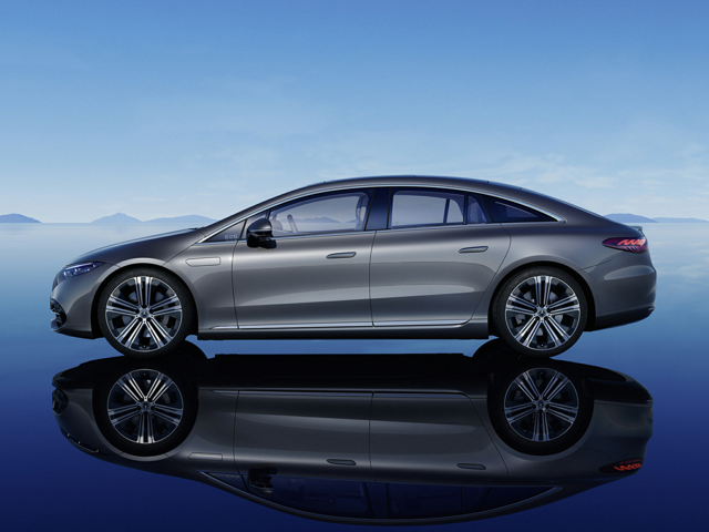 Profile of a grey luxury sedan reflecting on a blue surface.