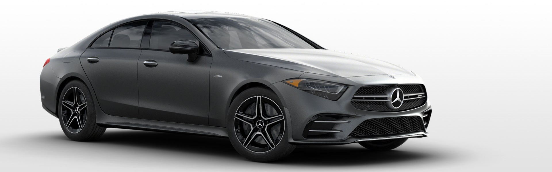 A dark grey Mercedes-Benz CLS 450 coupe, angled slightly, showcasing its sleek design and the Mercedes star emblem on the front grille.