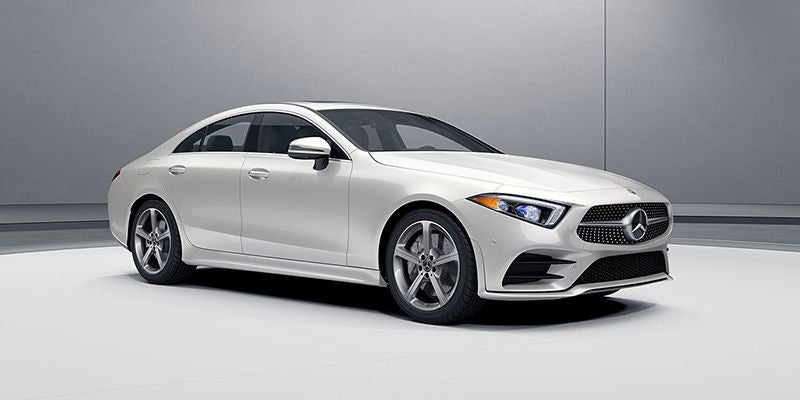 Front three-quarter view of a white luxury sedan in a studio