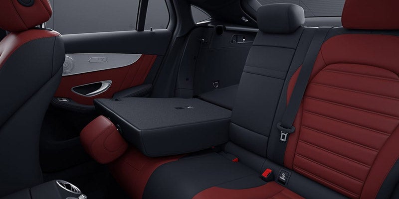 Interior view of black and red leather rear seats with armrest down.