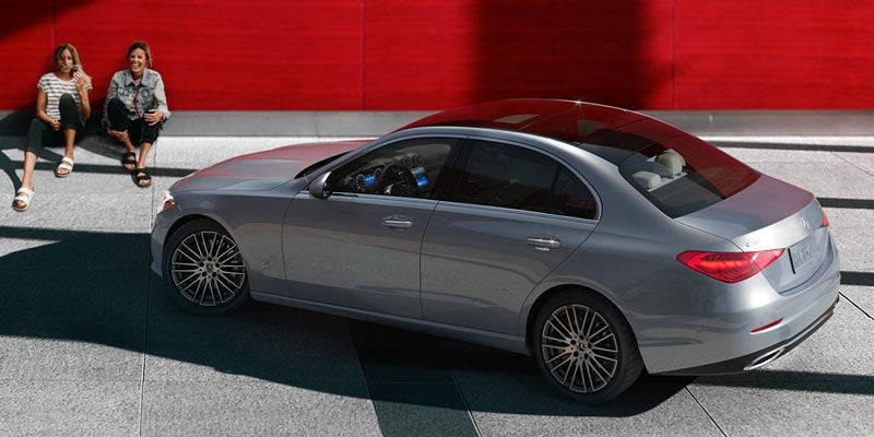Side profile of a silver Mercedes-Benz sedan parked outdoors.