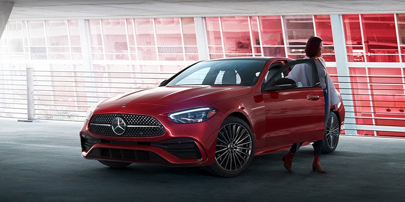 Front view of a dark red Mercedes-Benz with door open.