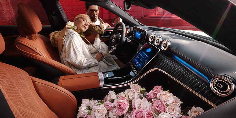 Interior view of a couple sitting in a luxury car cabin.