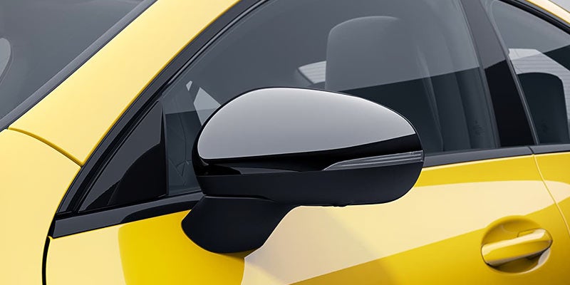 Close-up of a black side mirror on a yellow car