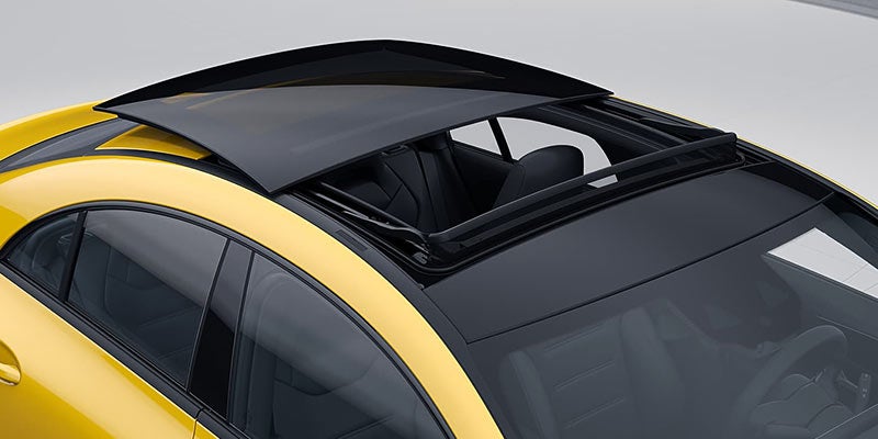 Exterior view of an open panoramic sunroof on a yellow car.