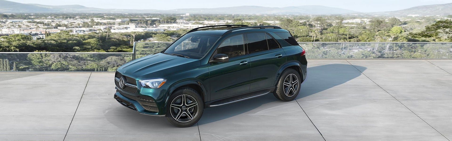 Dark emerald green Mercedes-Benz GLE parked on a high-altitude concrete terrace.