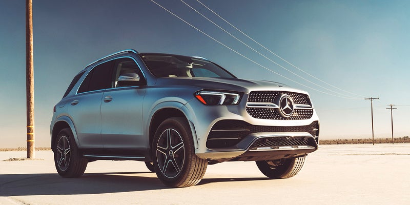 Silver Mercedes-Benz SUV parked on a light-colored sandy surface.