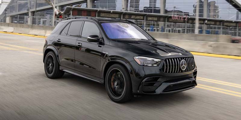 Side profile of a black Mercedes-Benz AMG SUV driving.