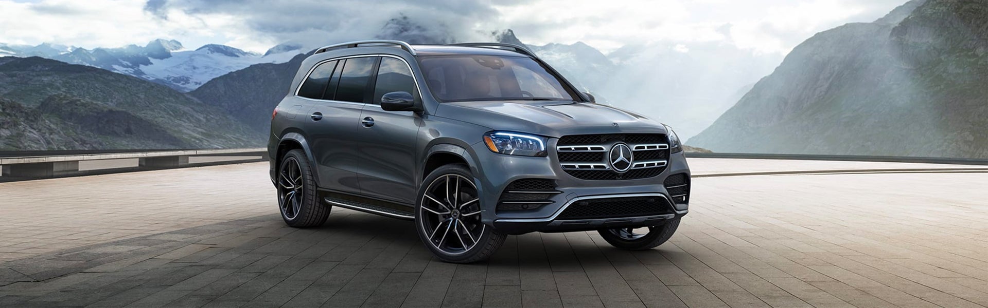 A gray Mercedes-Benz GLS SUV parked on a terrace with mountain views