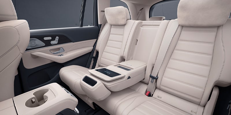 Interior view of cream-colored leather rear seats with center armrest