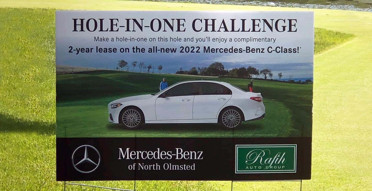 Sign on a golf course advertising a Hole-in-One Challenge to win a 2-year lease on a 2022 Mercedes-Benz.
