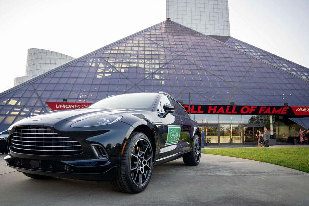 A black luxury SUV with Ruffi Auto on the side, parked in front of the Rock and Roll Hall of Fame building.