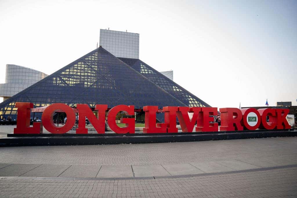 Large red letters spelling LONG LIVE ROCK stand before the pyramid-shaped Rock & Roll Hall of Fame.
