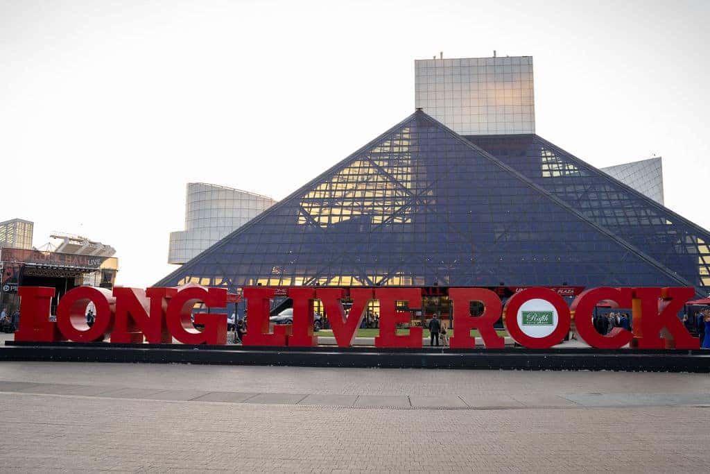 Red Long Live Rock sign in front of the Rock & Roll Hall of Fame's triangular glass building.