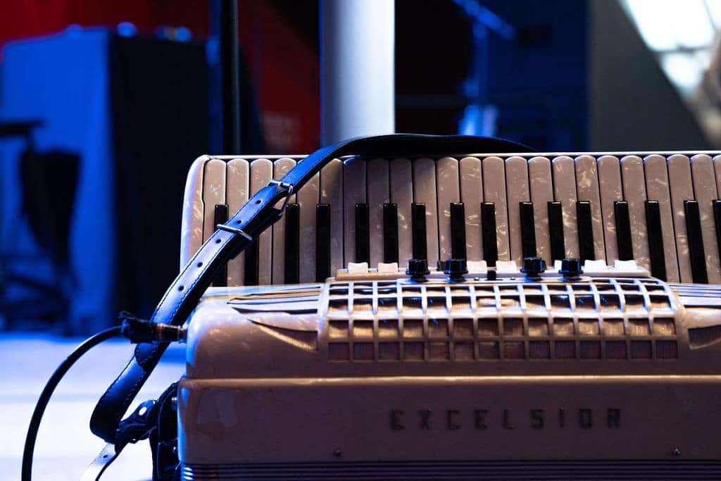 Close-up of an accordion with black and white keys, a black strap, and EXCELSIOR written on the front.