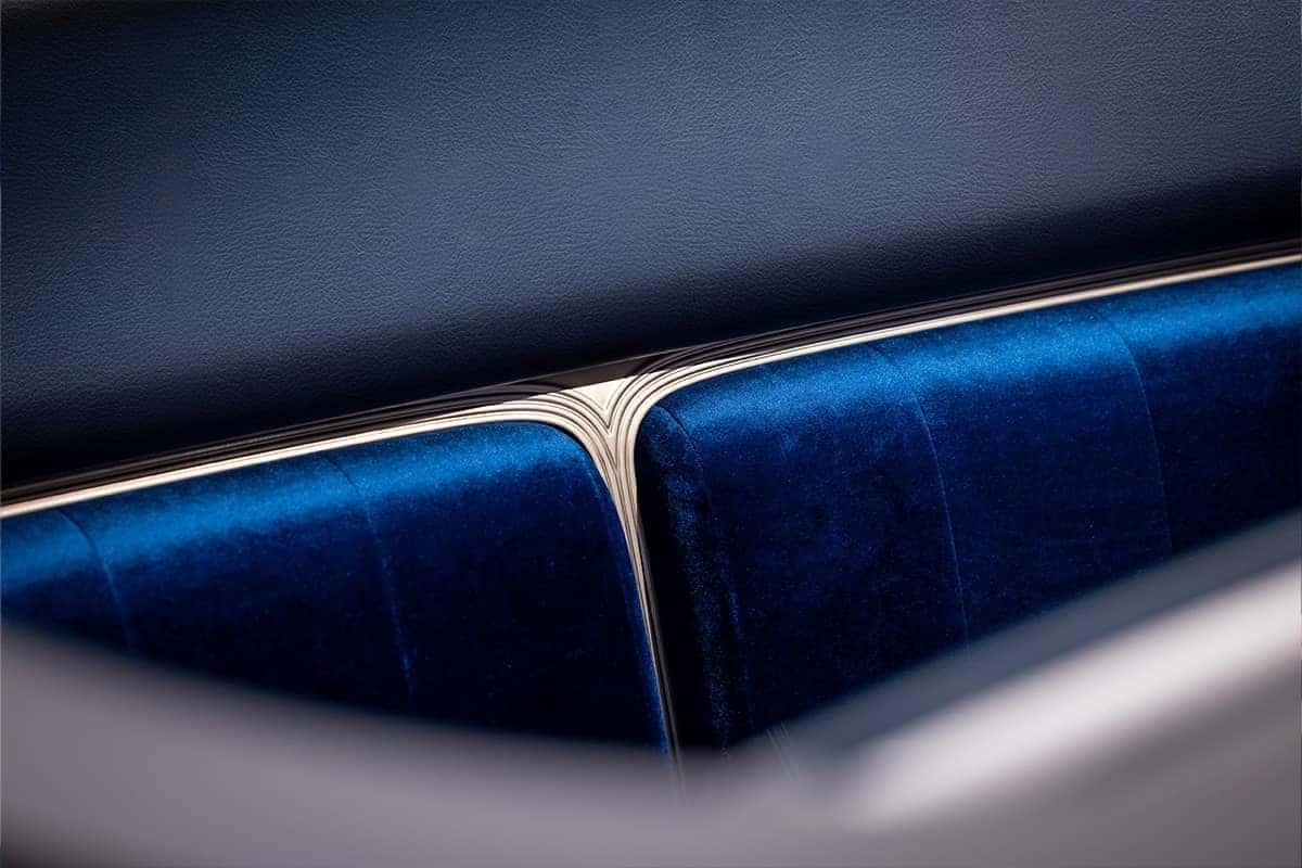 Close-up of a blue velvet car seat with sleek metallic trim in a modern interior design.