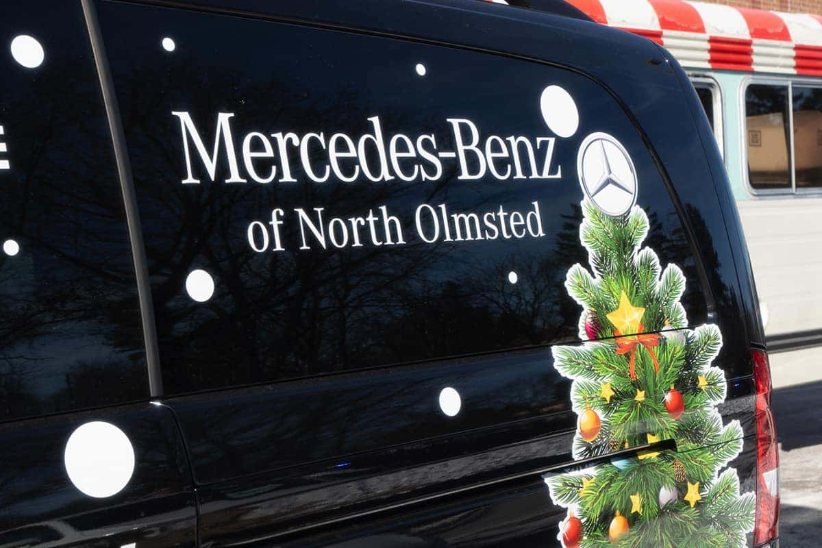 Mercedes-Benz of North Olmsted logo on a black van with a Christmas tree graphic.