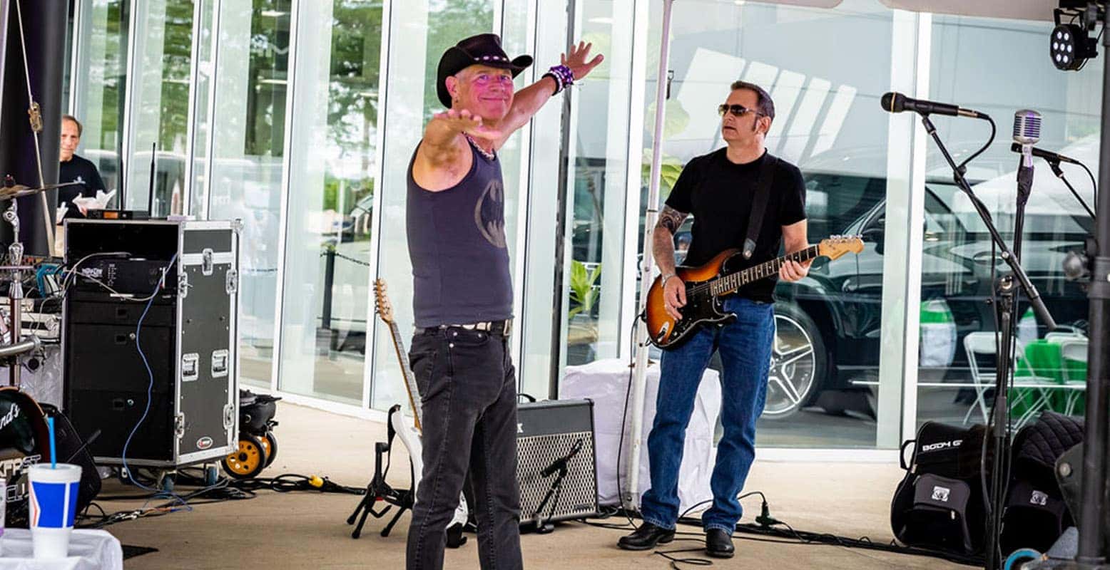 Two security officers, one pushing a cart, stand near a man holding Christmas headbands in a crowded Walmart.